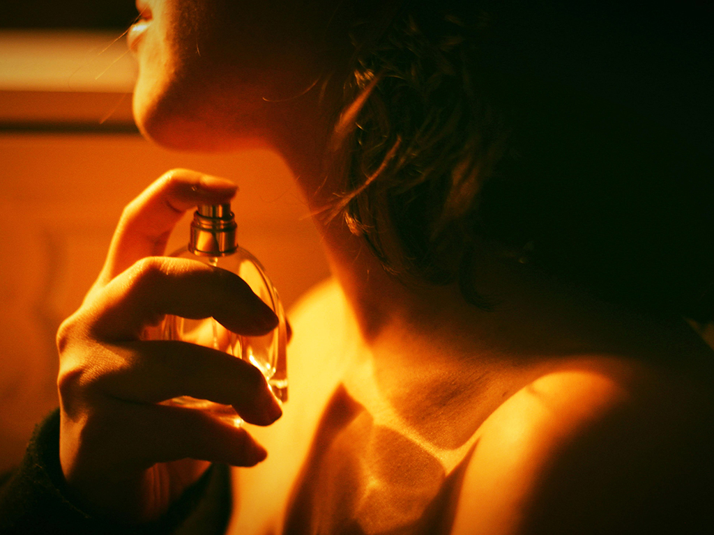 A woman spraying perfume on herself